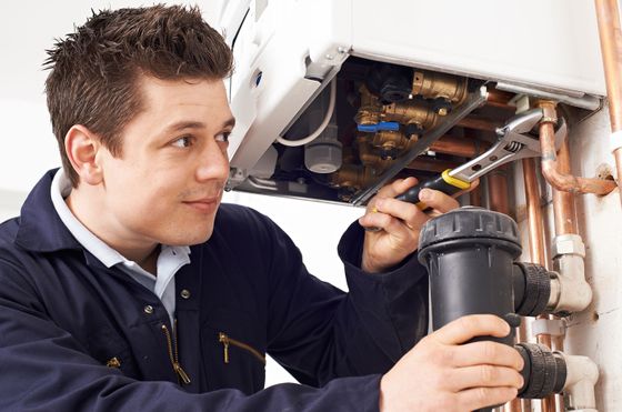 A plumber fixing a boiler